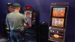 Funkcjonariusz Służby Celno-Skarbowej w nielegalnym salonie gier hazardowych, w tle automat do gry